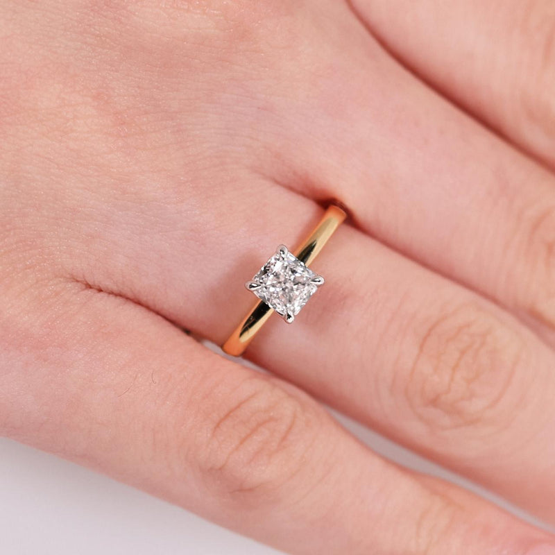 18ct rose gold 0.83ct cushion cut diamond solitaire ring in a four claw setting on finger