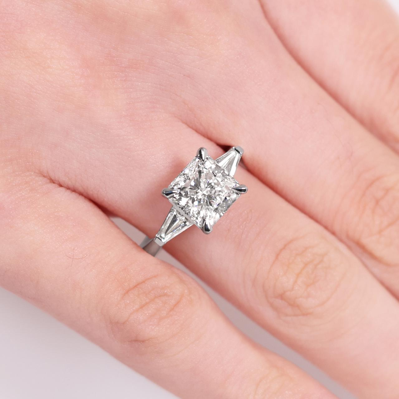 18ct white gold 3.01ct square radiant diamond and 2=0.38ct tapered baguette diamonds ring on finger