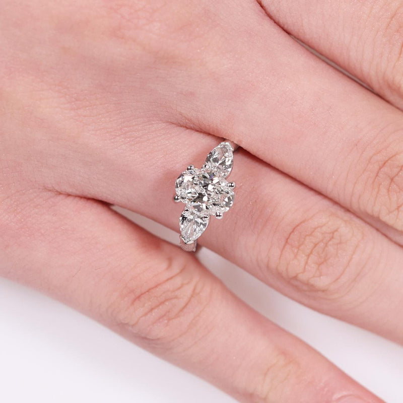 18ct white gold 1.20ct oval brilliant cut diamond and 2=0.60ct pear shaped diamonds ring on finger