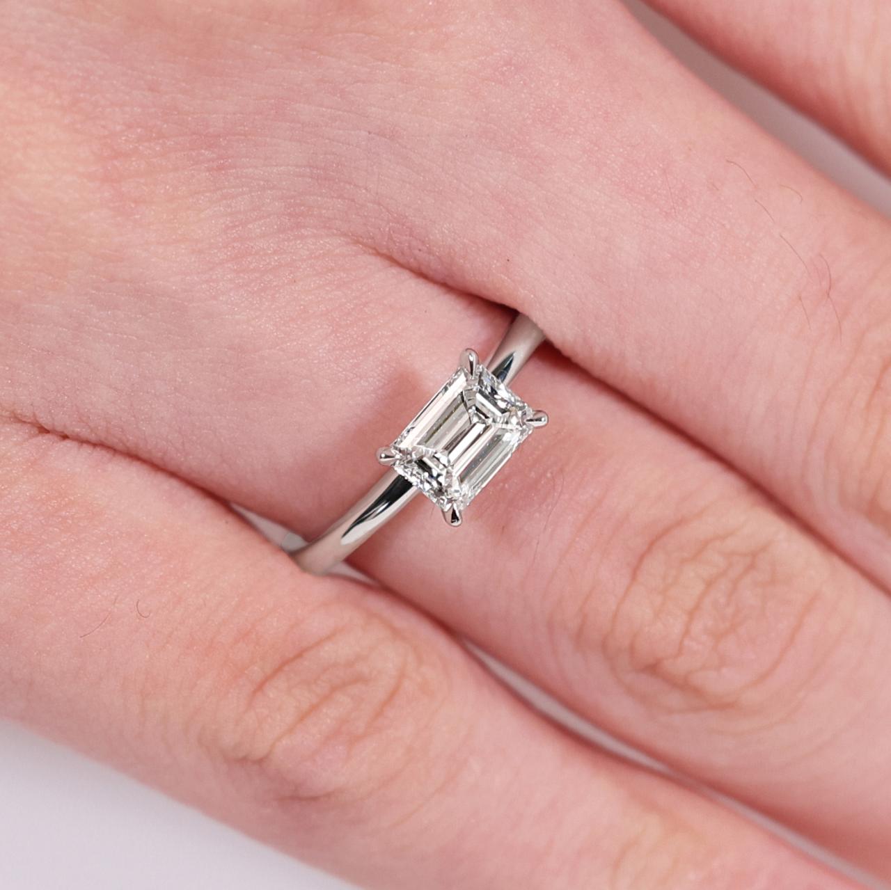 18ct yellow and white gold 1.00ct  emerald cut diamond solitaire ring on finger