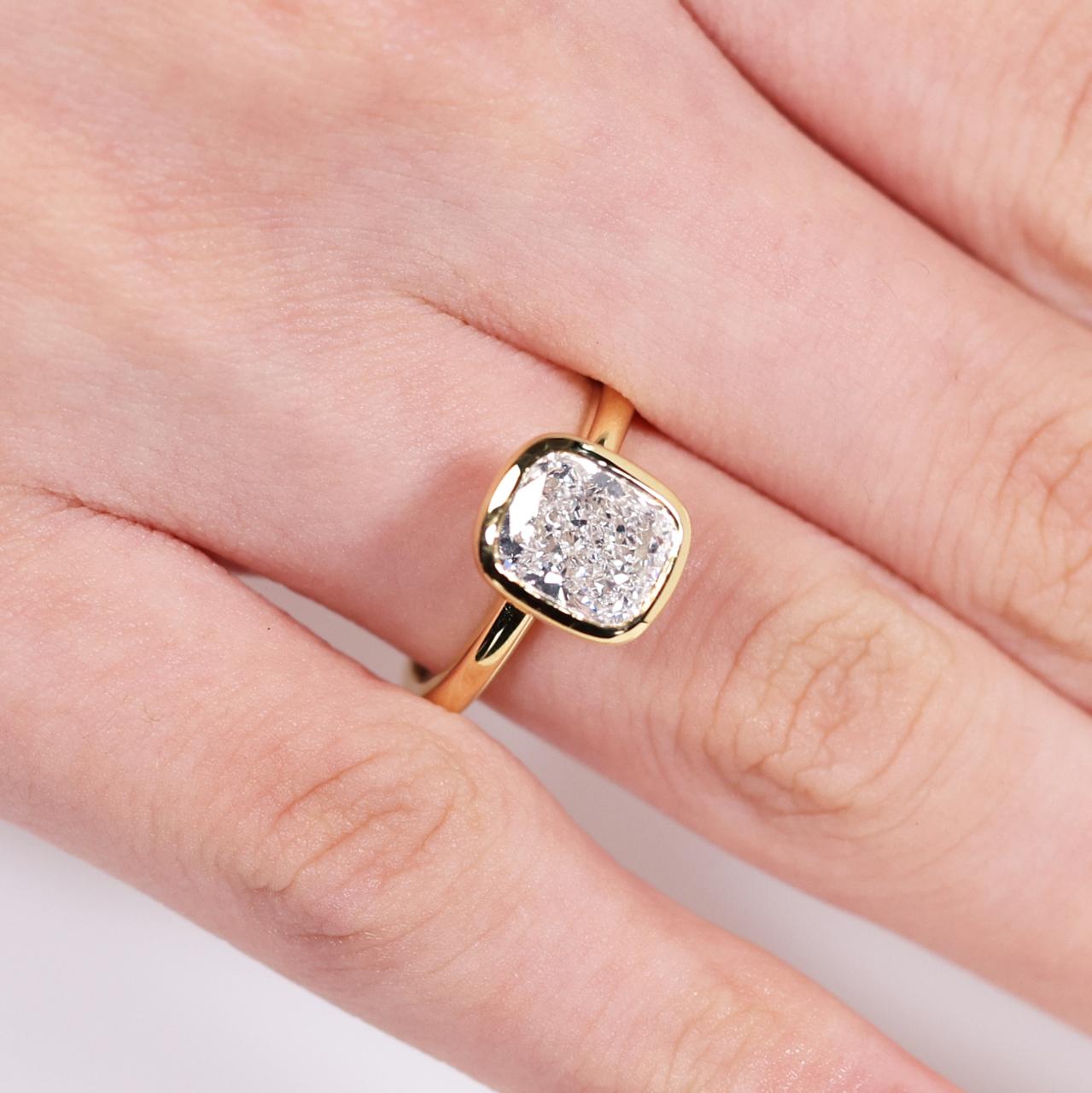 18ct yellow gold 2.11ct E VS1 cushion brilliant cut LAB Grown Diamond ring on finger