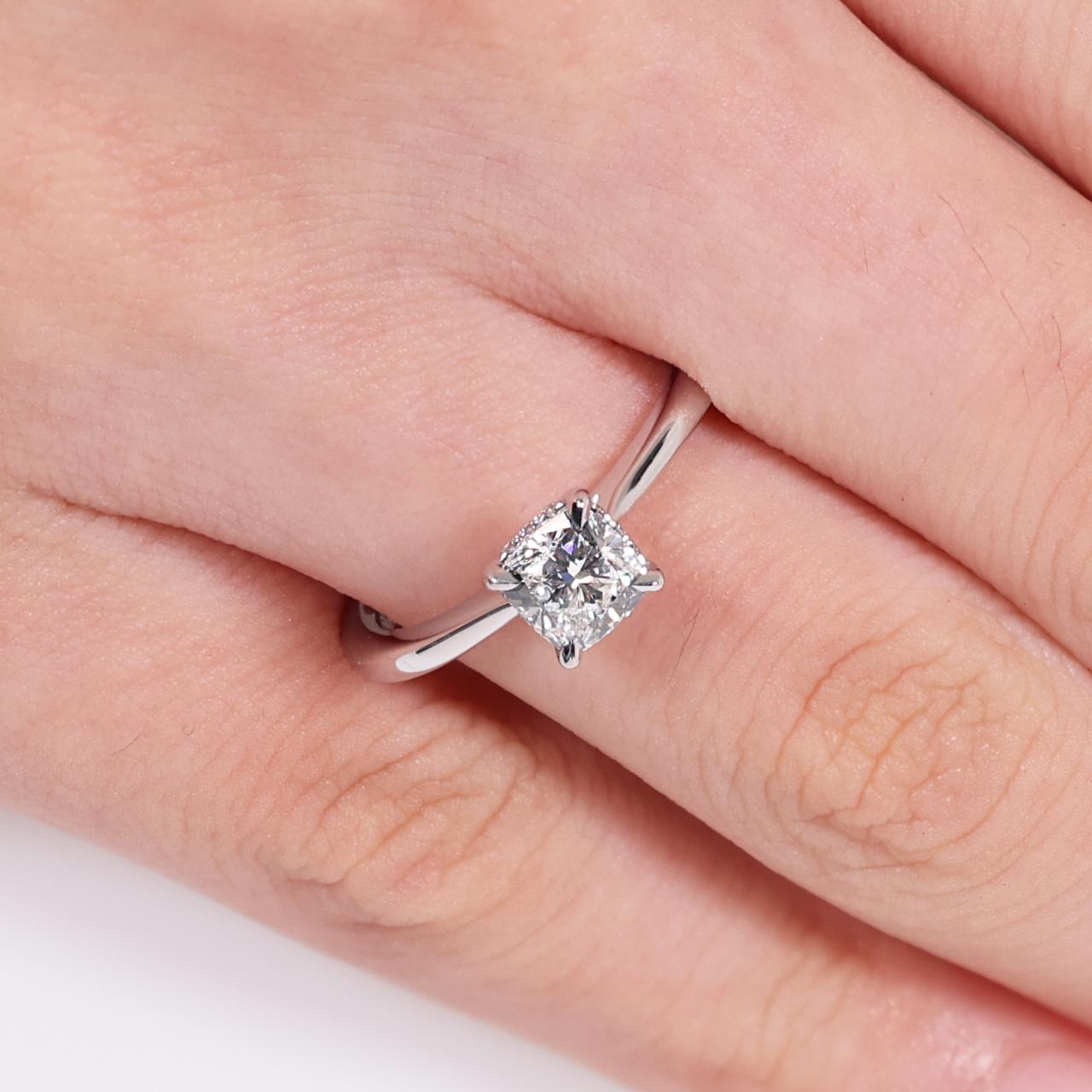 18ct white gold 0.80ct cushion cut diamond and 12=0.05ct round brilliant cut diamonds ring with hidden halo on finger