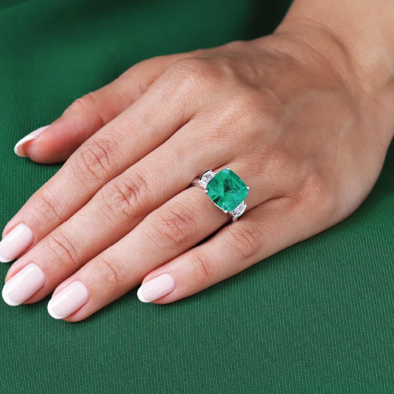 18ct white gold cushion cut Colombian Emerald and Cadillac diamond ring on the finger