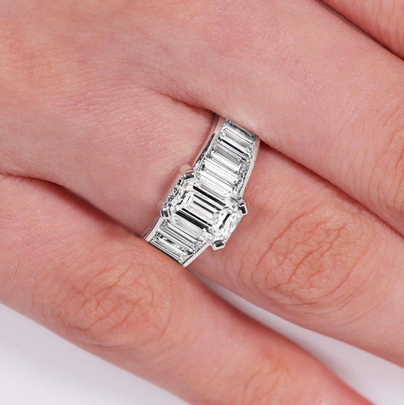 18ct White gold emerald cut diamond engagement ring with baguette cut diamonds on the band on the finger