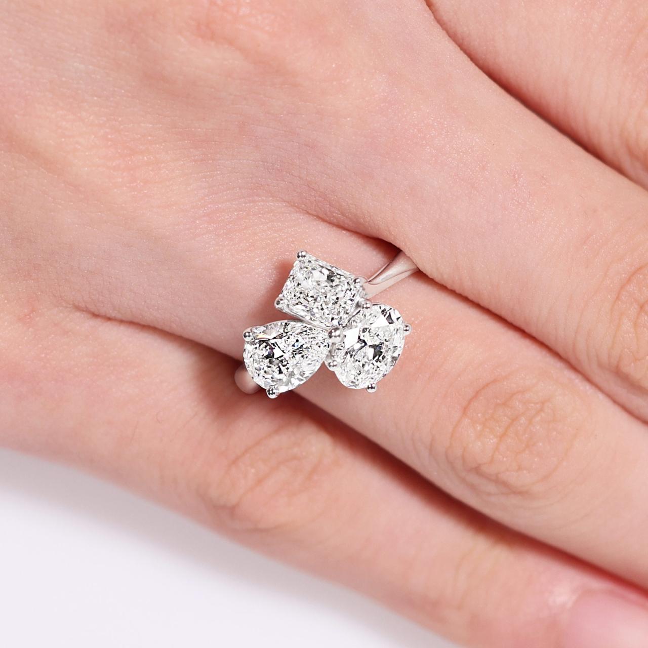 18ct white gold oval, pear and radiant diamond engagement ring on the finger