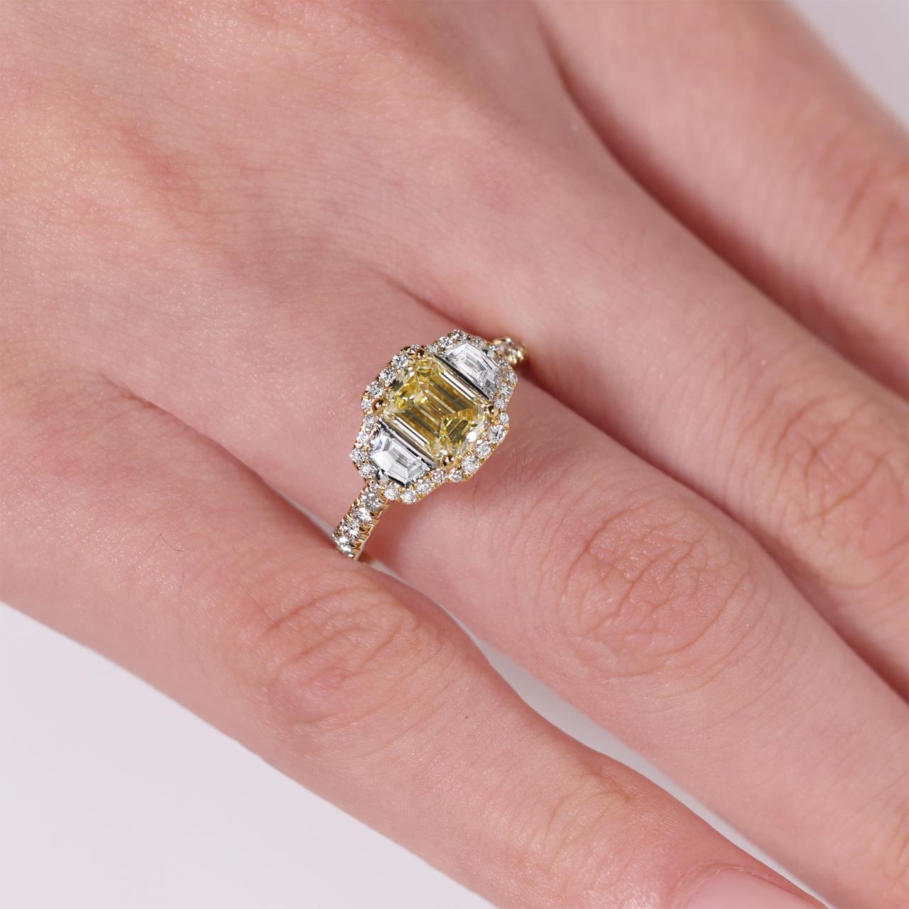 18ct yellow gold Fancy Intense Yellow emerald cut diamond engagement ring with cadillac step cut diamonds on the side on the finger