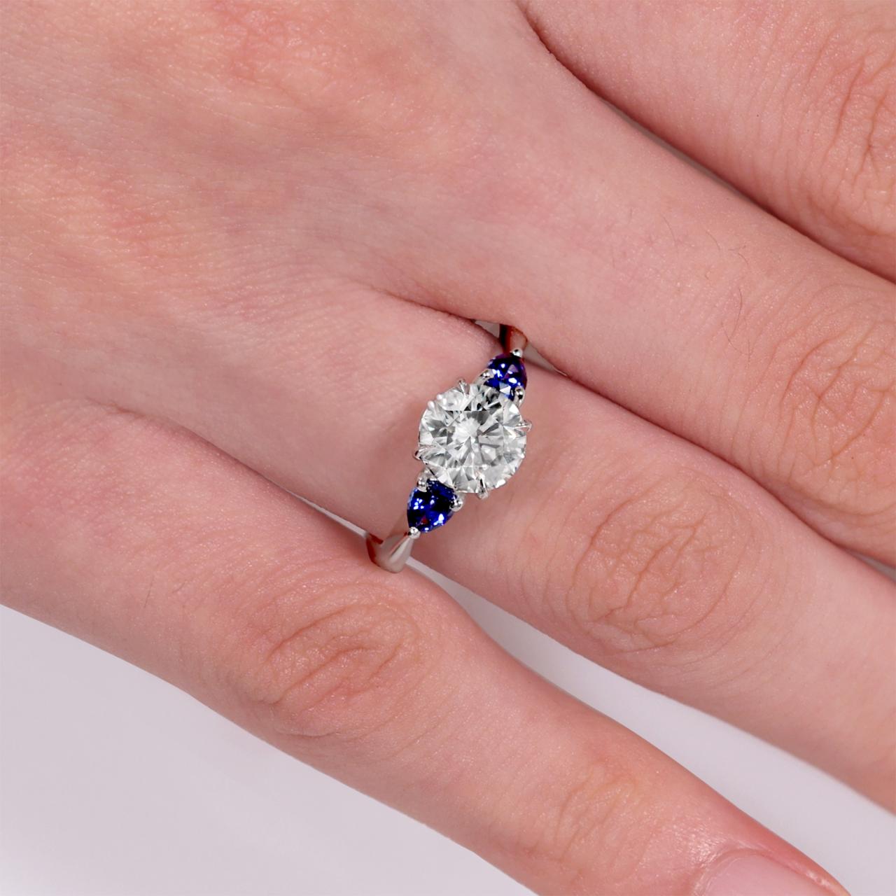 18ct white gold Round Brilliant Cut LAB Grown Diamond and Ceylon blue sapphires engagement ring on the finger
