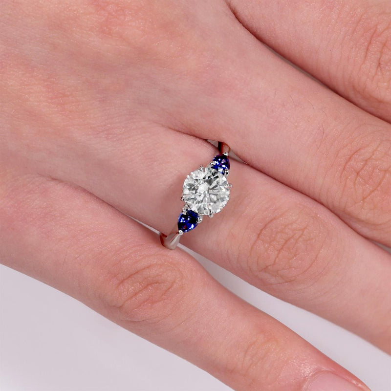 18ct white gold Round Brilliant Cut LAB Grown Diamond and Ceylon blue sapphires engagement ring on the finger