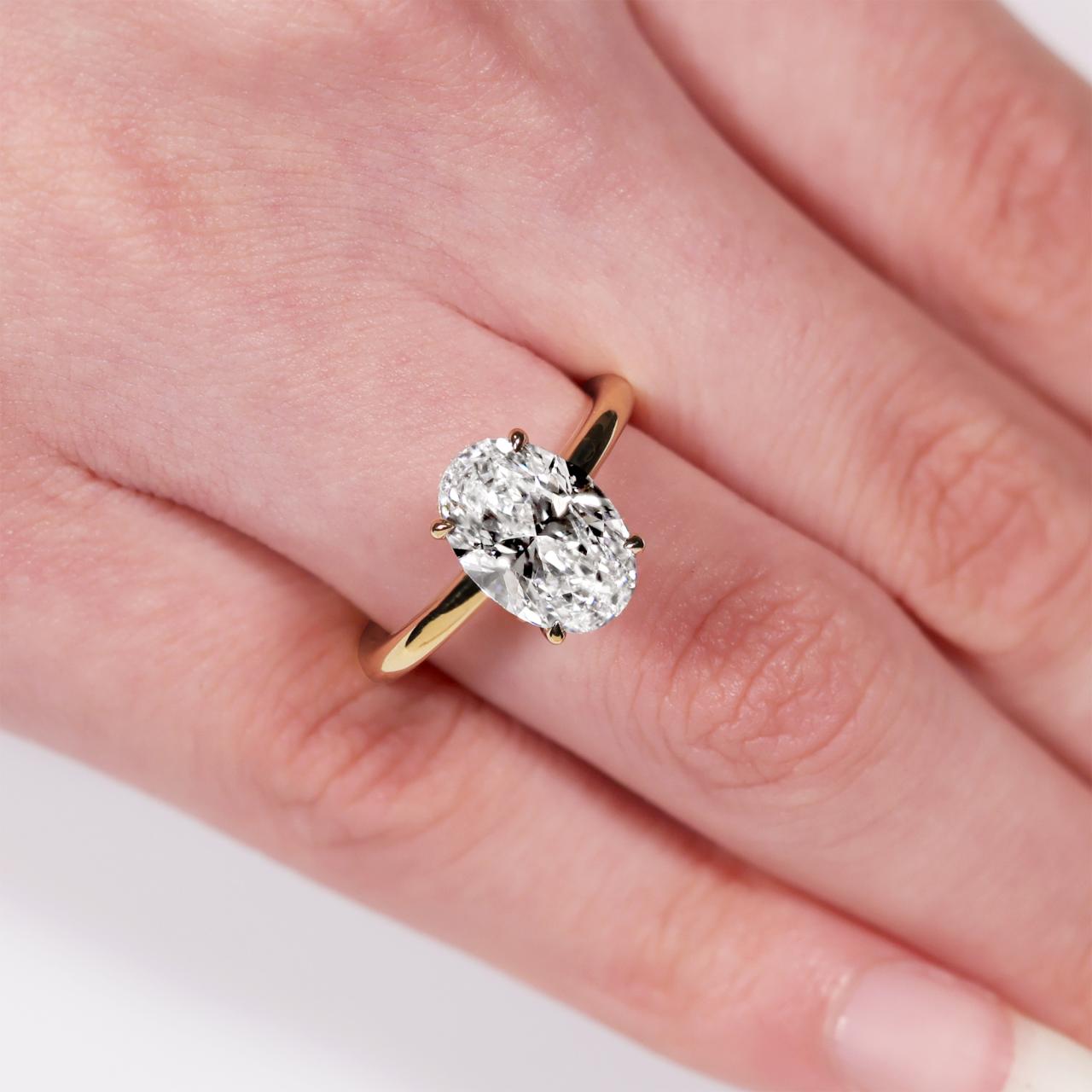 MILAN 18ct yellow gold 2.96ct D VVS2 oval lab grown diamond ring in a four claw setting with hidden halo. IGI Cert
