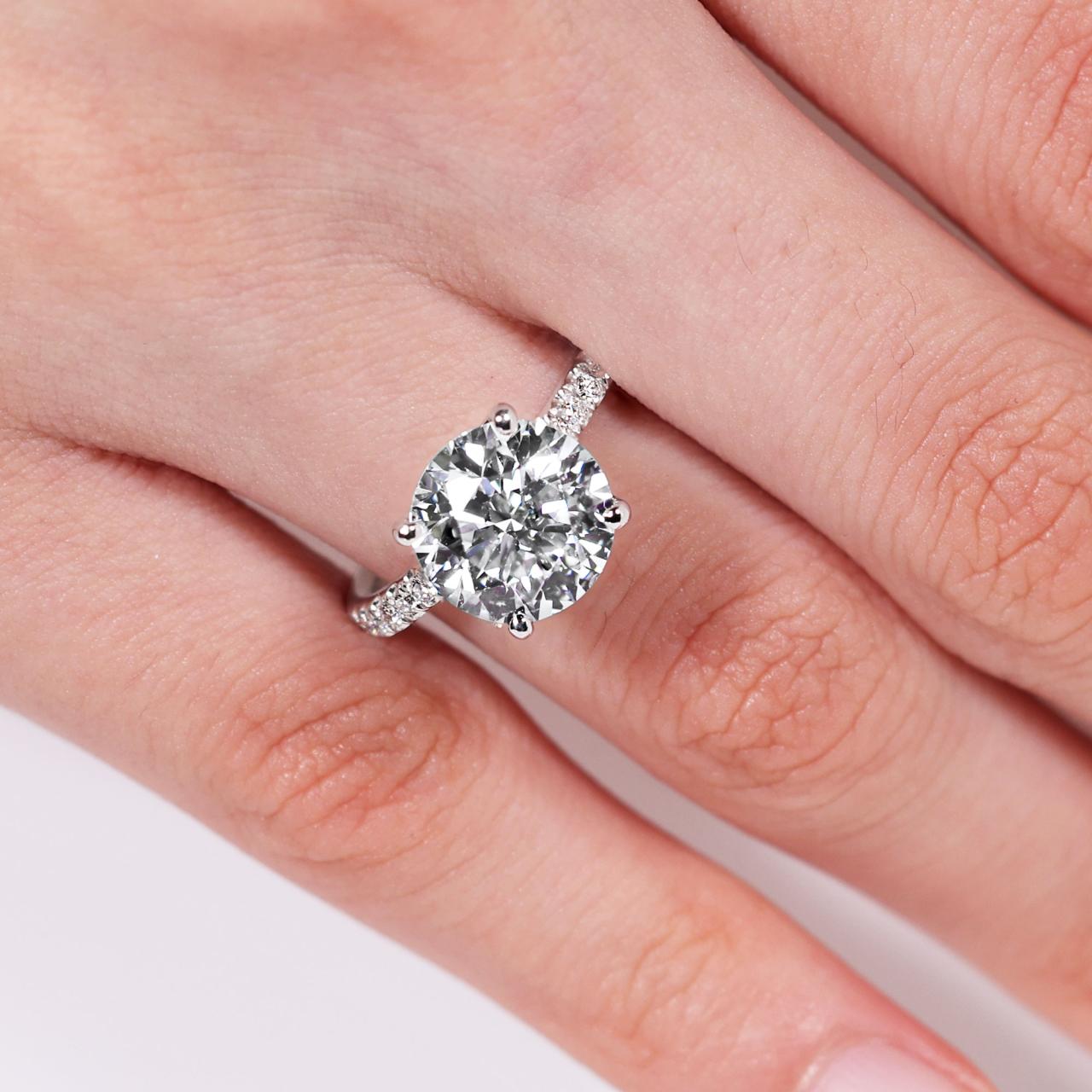 18ct white gold round briliant cut diamond engagement ring in a four claw setting with a hidden halo and diamond band. GIA cert