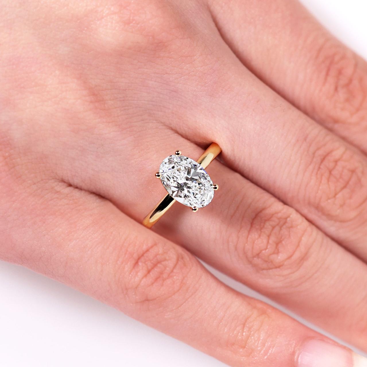 MILAN - 18ct yellow gold oval lab grown diamond solitaire ring on the finger
