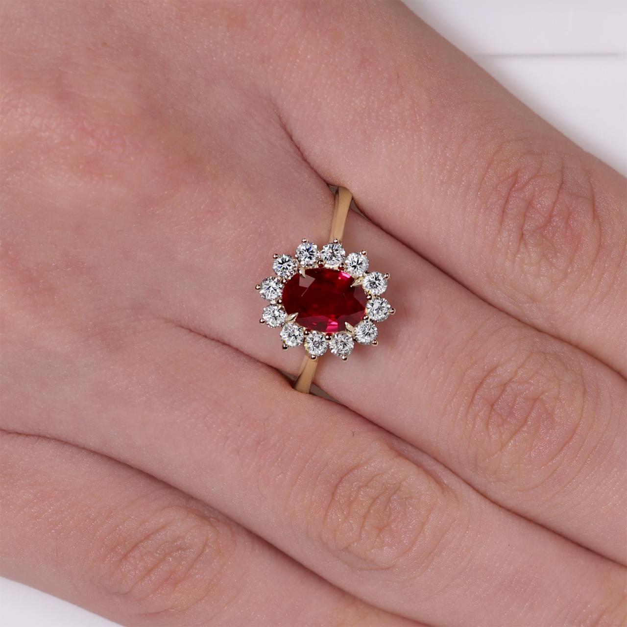 18ct yellow and white gold 1.12ct oval cut ruby and diamond ring on the finger