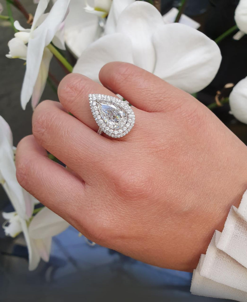 Platinum 3.01ct pear and round brilliant cut double halo pave set ring on finger
