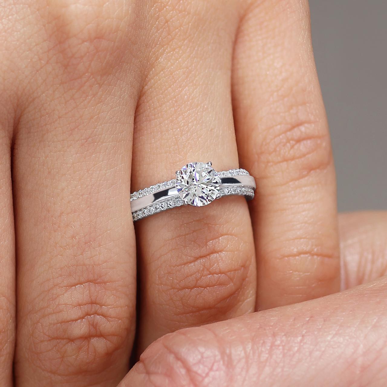 18ct white gold 1.02ct round brilliant cut diamond ring in a four claw setting with RBC diamonds in pave setting