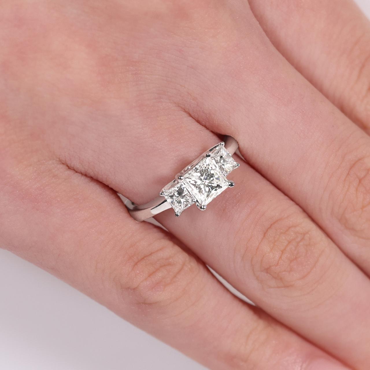 18ct White Gold 3 stone Engagement ring featuring a 1.02ct Princess Cut Diamond in the centre and Princess Cut Diamonds on either side on finger