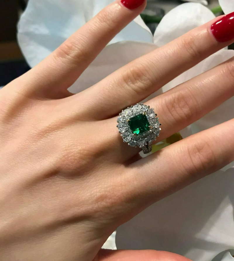 18ct white and yellow gold GRS certified vivid green Brazilian emerald, oval and round brilliant cut diamond double halo split band ring on the finger