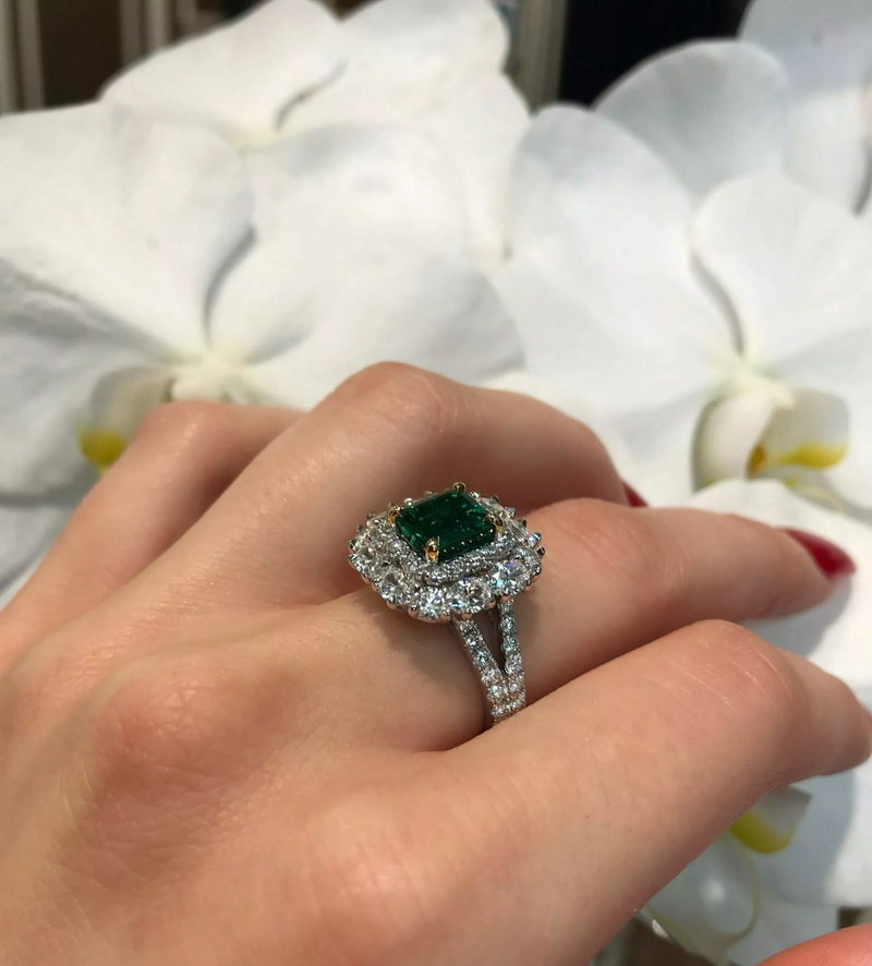 18ct white and yellow gold GRS certified vivid green Brazilian emerald, oval and round brilliant cut diamond double halo split band ring on the finger