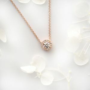 18ct rose gold 0.32ct round diamond halo necklace.